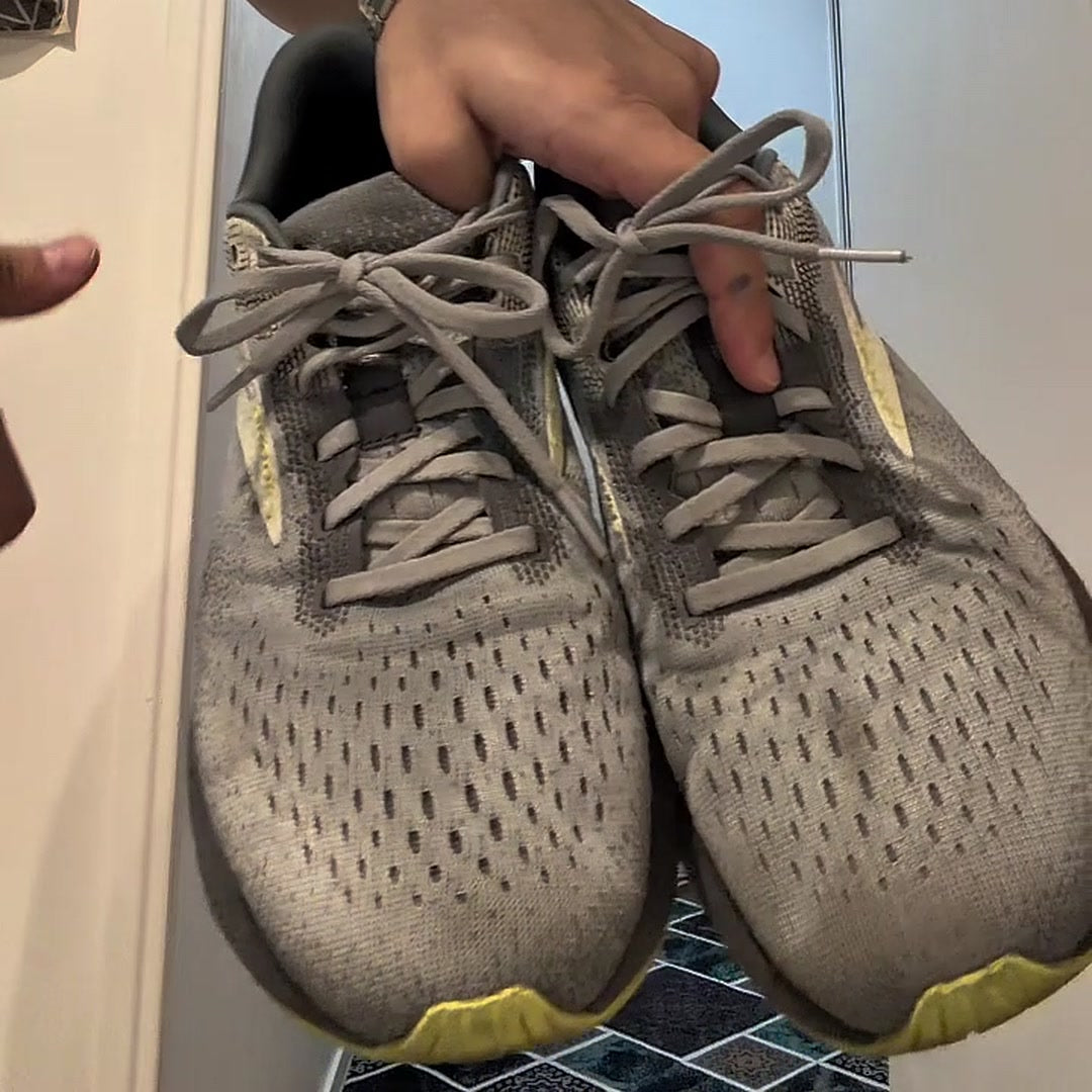 Paire de baskets grises couvertes de poussière, avant lavage